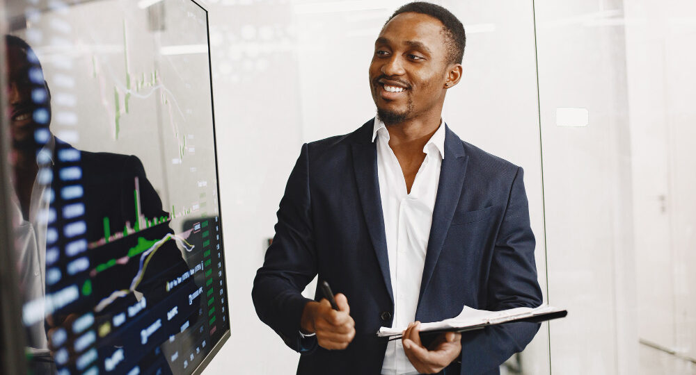 african-man-black-suit-big-tv-screen-guy-shows-presentation